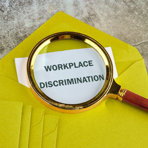 Magnifying glass over envelope highlighting workplace discrimination concerns