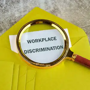 Magnifying glass over envelope highlighting workplace discrimination concerns