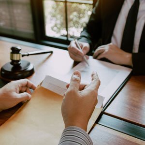 Businesswoman holding charts with blurred meeting in background.